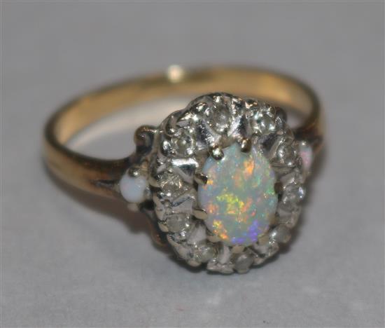 An 18ct gold, white opal and diamond set oval cluster ring, size M.